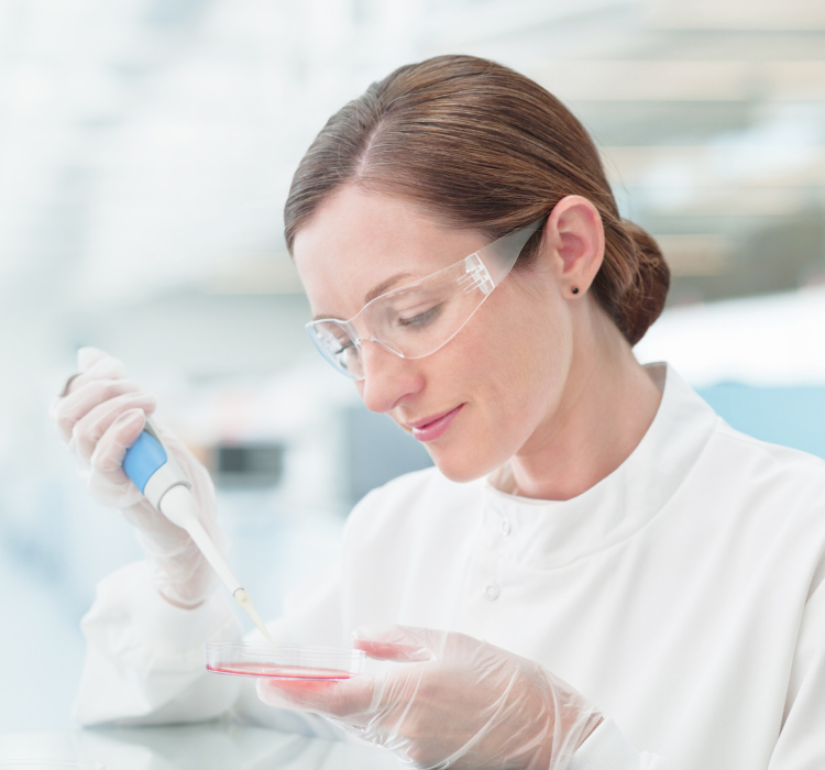 A female scientist in a lab coat holds a test tube, conducting experiments in a laboratory setting.